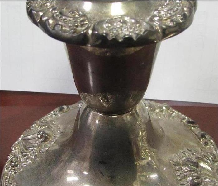 Candle holder tarnished by soot and smoke