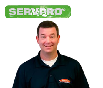 Brian Bell for SERVPRO photo on white wall, male employee in black polo
