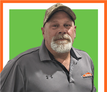 Kevin Woodard for SERVPRO photo on white wall, male employee in black shirt