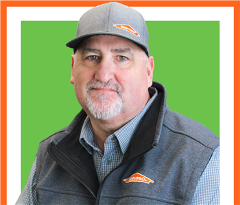 Jeff Williams for SERVPRO photo on white wall, male employee with hat on