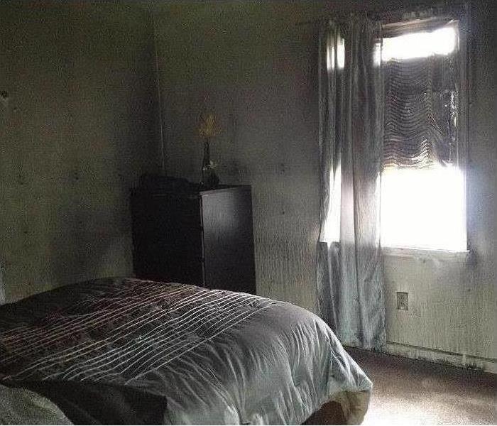 smoke and soot damage left behind in a bedroom after a fire